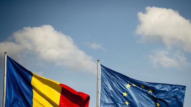 Europa- und Rumänien-Flagge wehen im Wind.