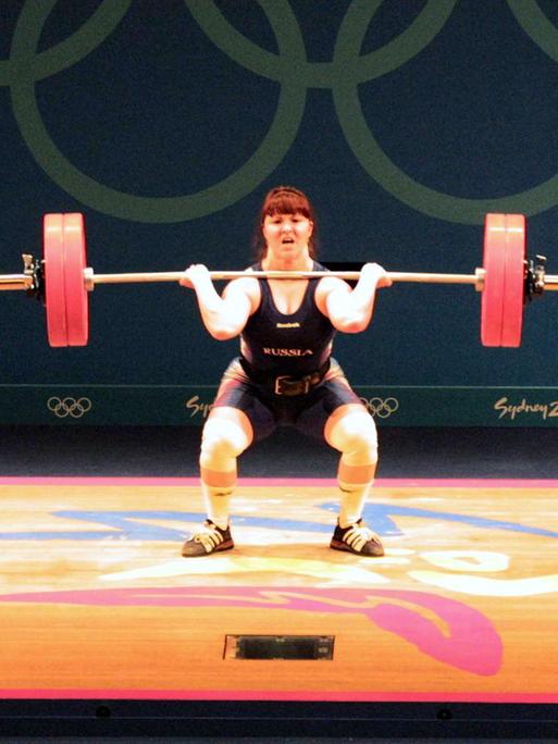 Die Gewichtheberin Swetlana Kabirowa steht auf einem Podest in der Hocke, sie drückte die Gewichte nach oben