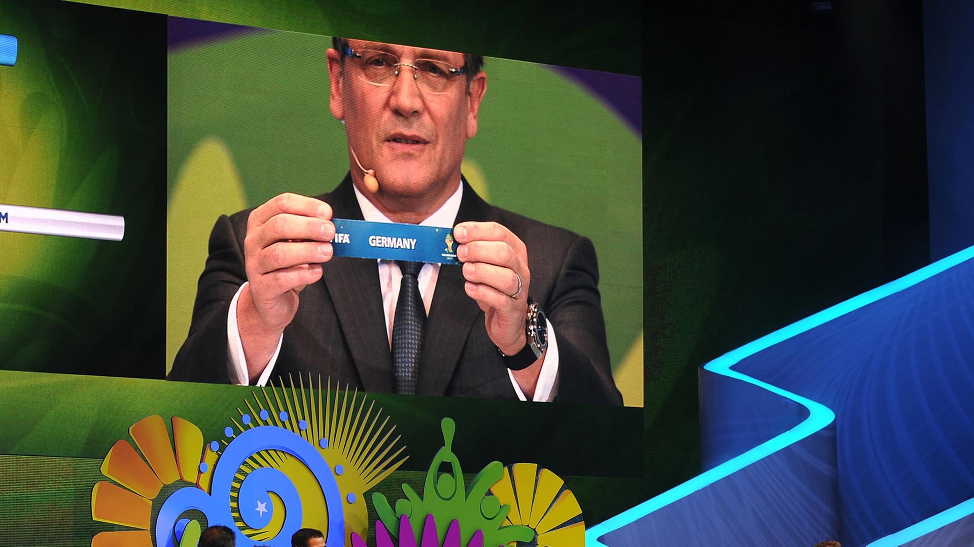 Auf einer Leinwand ist Fifa-Generalsekretär mit einem Los zu sehen, auf dem "Germany" steht.