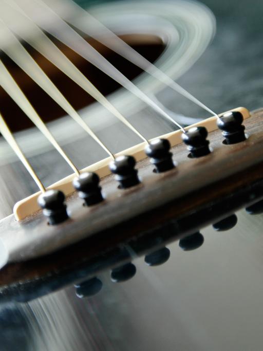 Der Steg und die Saiten einer "Martin SPD-16 Special Edition" glänzen im Sonnenlicht. Diese Westerngitarre ist ein von Johnny Cash lizenziertes Modell, von dem es weltweit nur zwei Exemplare gibt.