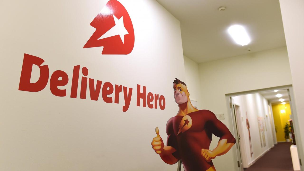 Das Logo von "Delivery Hero" und die Werbefigur von "Lieferheld" in der Firmenzentrale der Bestell-Plattformen in Berlin
