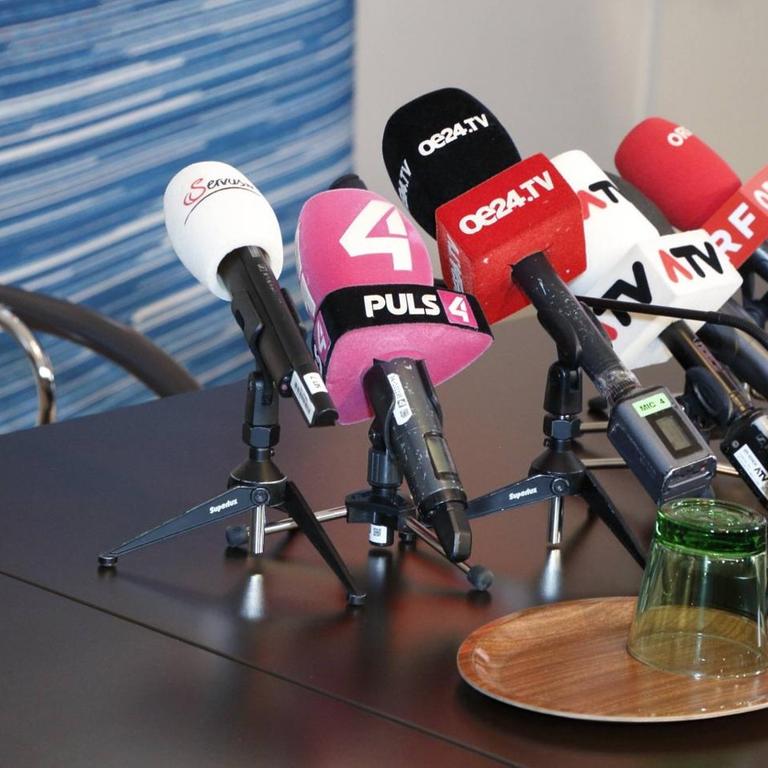 Auf einem Tisch stehen mehrere Mikrofone.