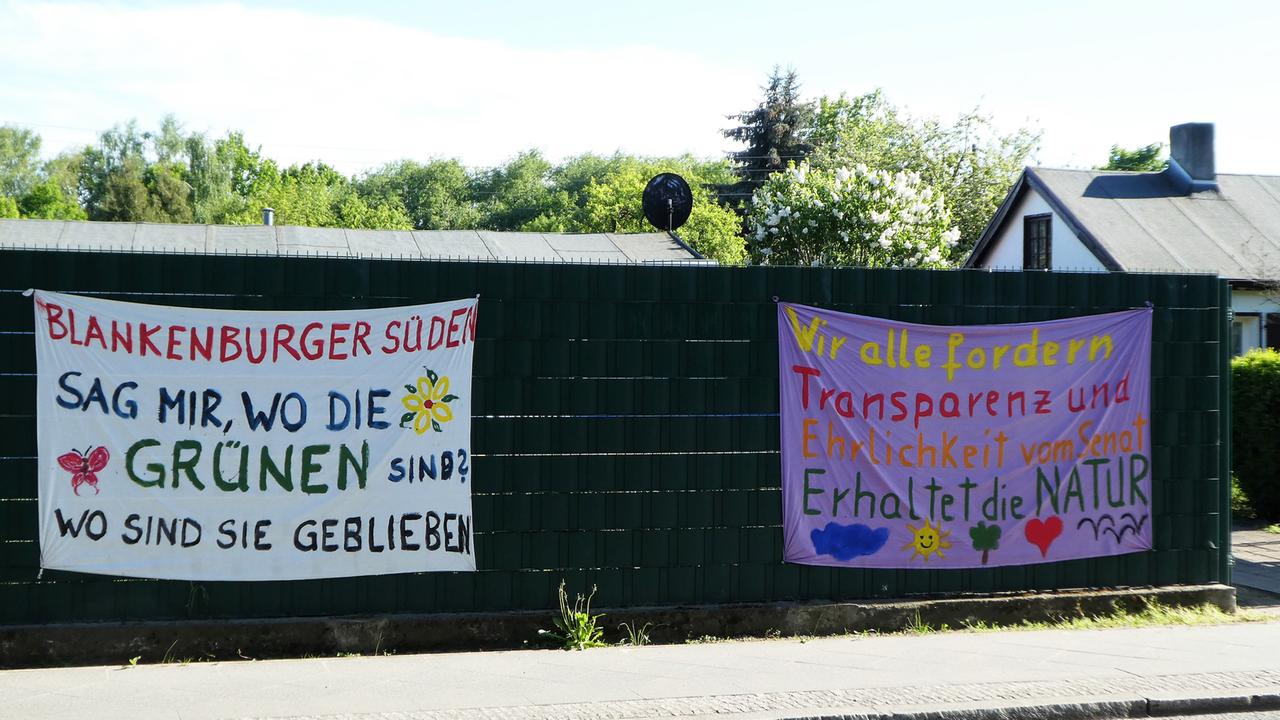 Bunte Plakate gegen drohende Wohnbebauung in der Erholungsanalage Blankenburg in Berlin.