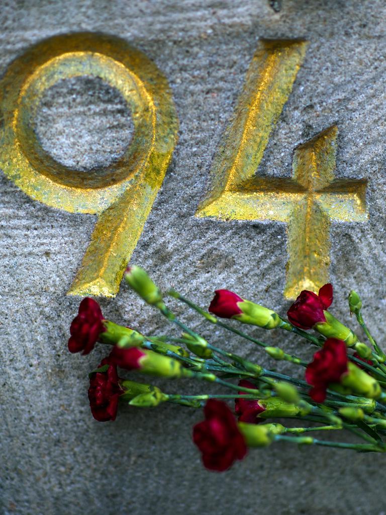 Vor der Jahreszahl "1945" auf einem Mahnmal auf dem Sowjetischen Garnisonfriedhof in Dresden (Sachsen) liegt ein Strauß roter Nelken.