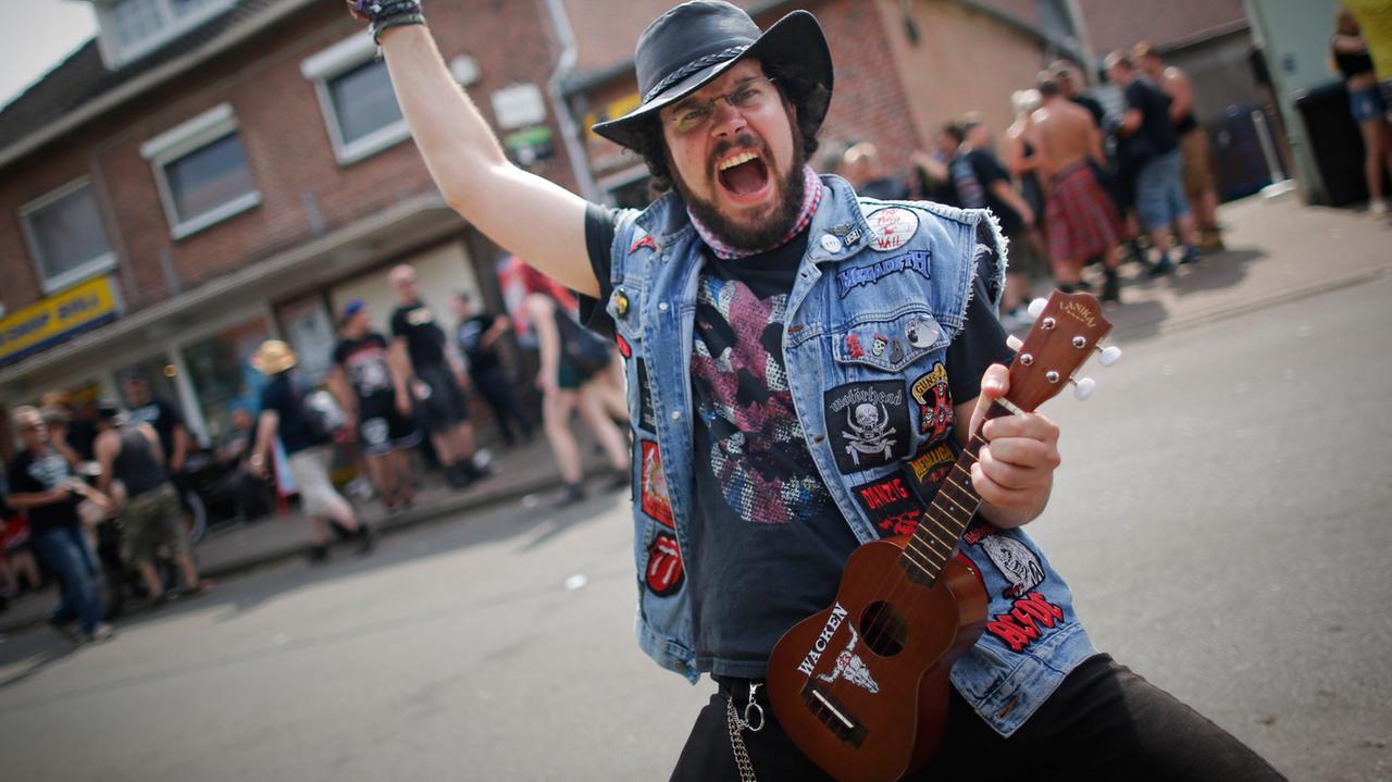 Ein Metal-Fan posiert mit seiner Ukulele beim 24. Heavy Metal Wacken Open Air Festival (WOA) 2013 in Wacken.