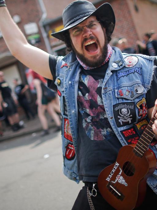 Ein Metal-Fan posiert mit seiner Ukulele beim 24. Heavy Metal Wacken Open Air Festival (WOA) 2013 in Wacken.