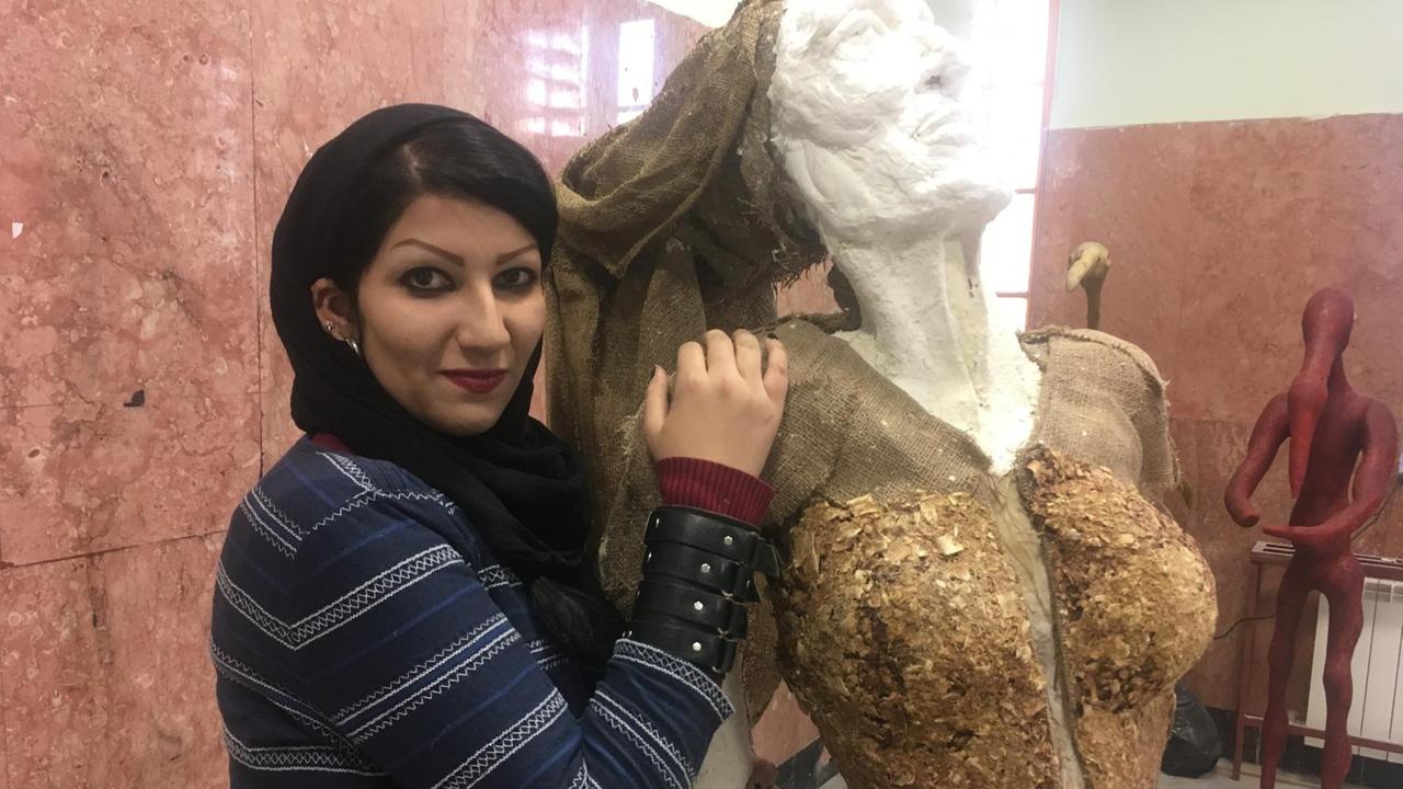 Eine Kunststudentin der Kunsthochschule in Teheran vor einer Skulptur.