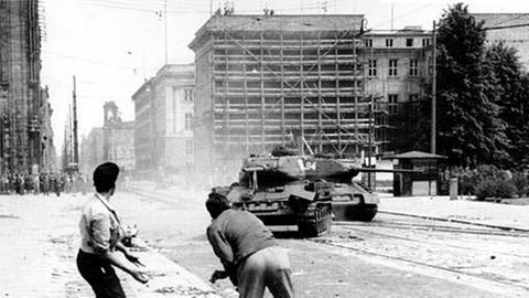 Demonstranten werfen in Berlin Steine auf einen sowjetischen Panzer, 17. Juni 1953.