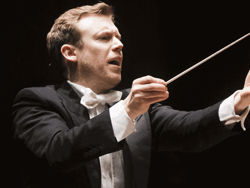 Daniel Harding beim Dirigieren mit erhobenen Händen und animierenden Blick.