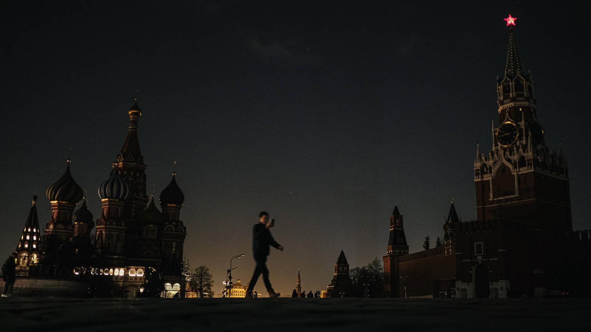 Ein Mann läuft in der Dunkelheit über den Roten Platz in Moskau, auf dem wegen der "Earth Hour" die Lichter ausgeschaltet sind.