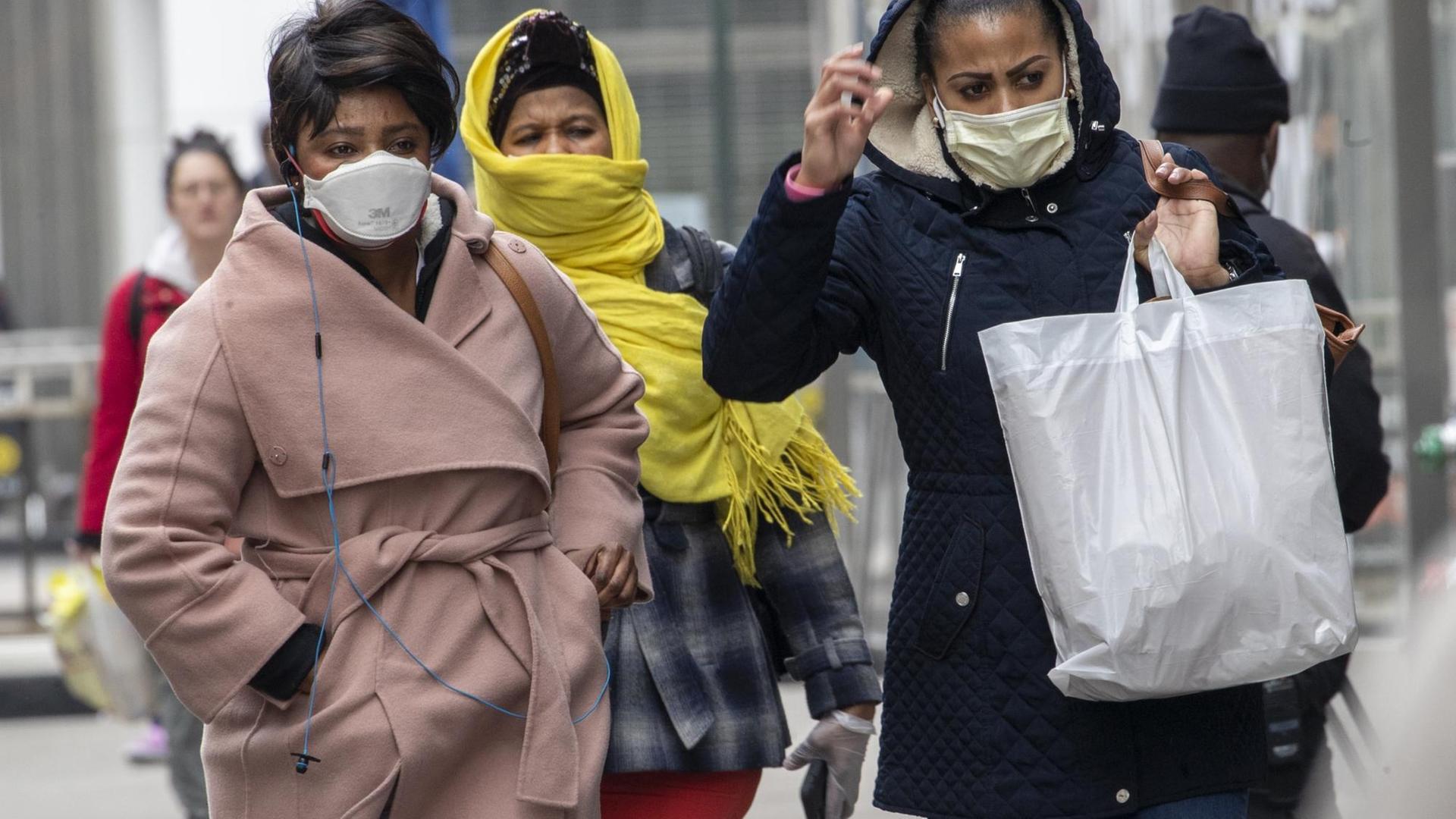 In den USA laufen drei Frauen mit Mund-Schutz.