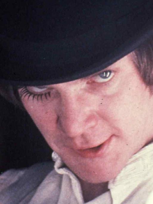 Filmszene aus Uhrwerk Orange von Stanley Kubrick zeigt Malcolm McDowell als Alex mit einem Glas Milch.
