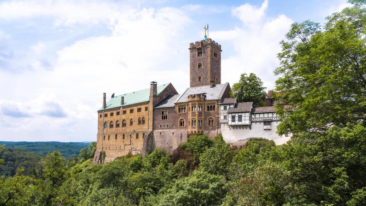 Blick auf die große Anlage der Wartburg auf einem Felsen, fotografiert an einem Sommertag. Blick auf die große Anlage der Wartburg auf einem Felsen, fotografiert an einem Sommertag.