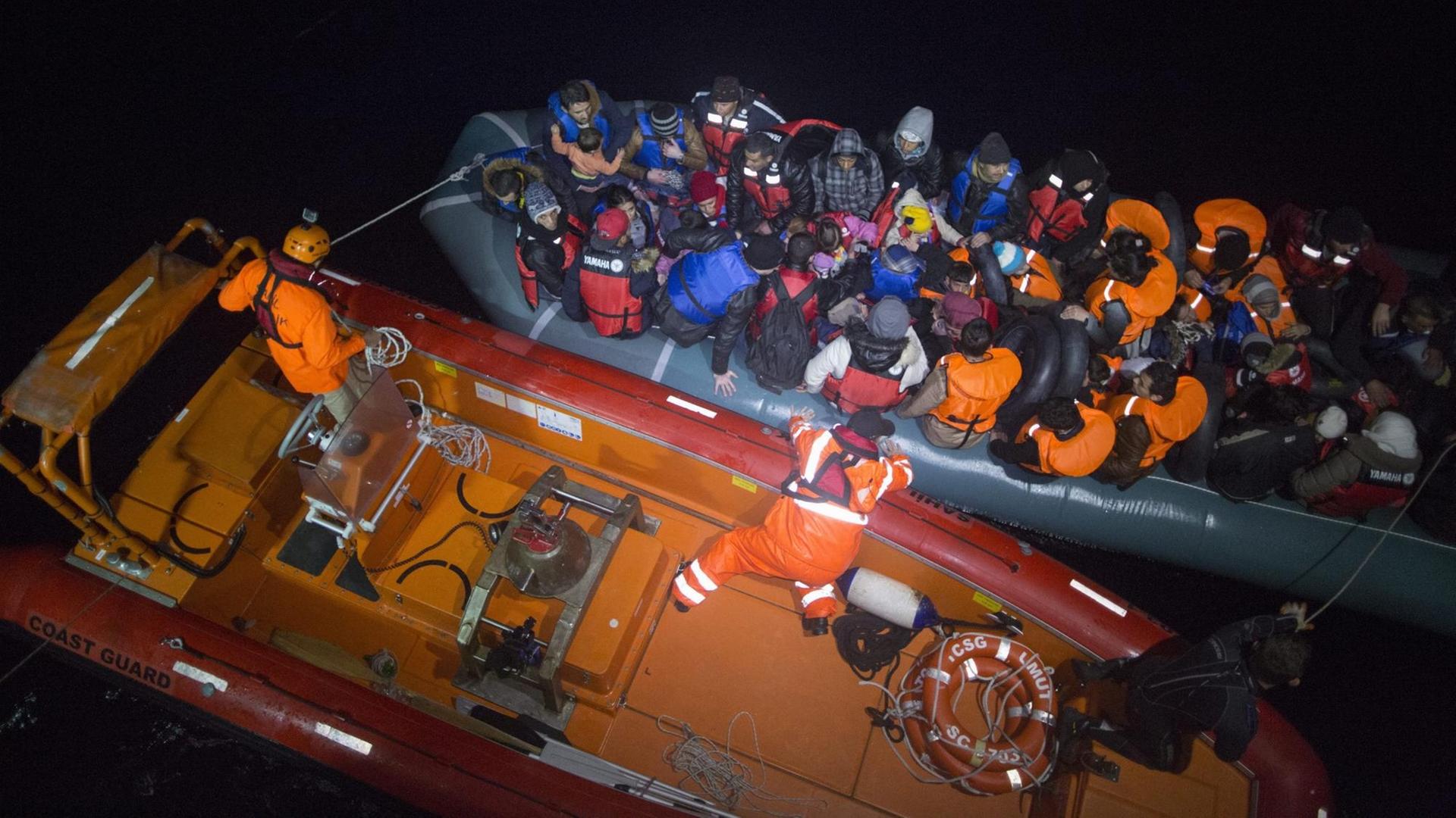 Zwei Boote liegen im Dunkeln auf dem Meer nebeneinander. 