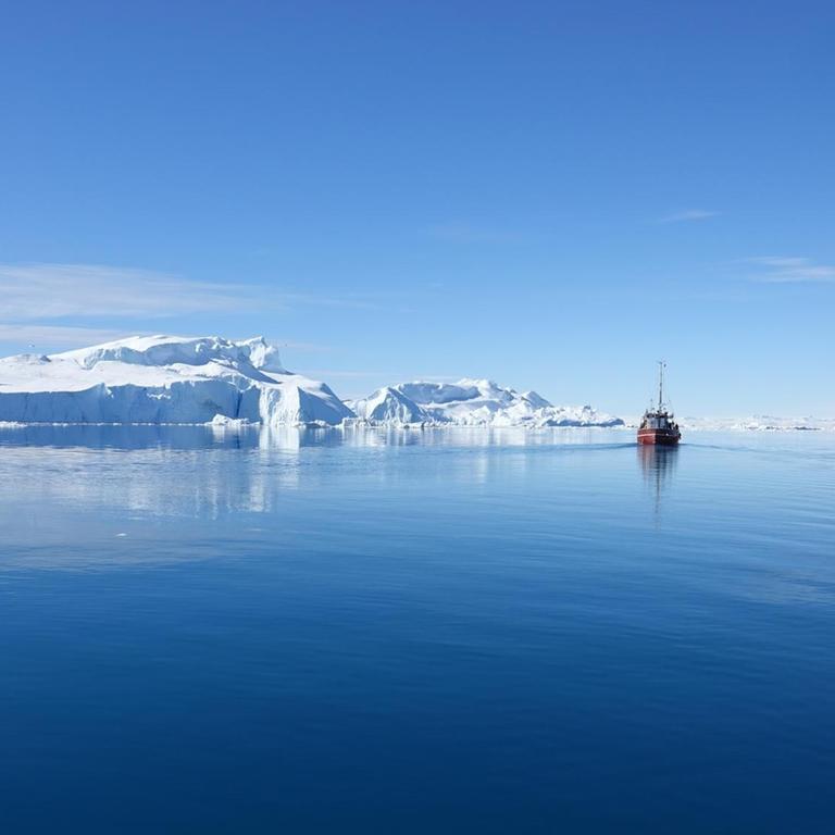 Ein Schiff fährt auf dem Eisfjord Ilulissat in Grönland.