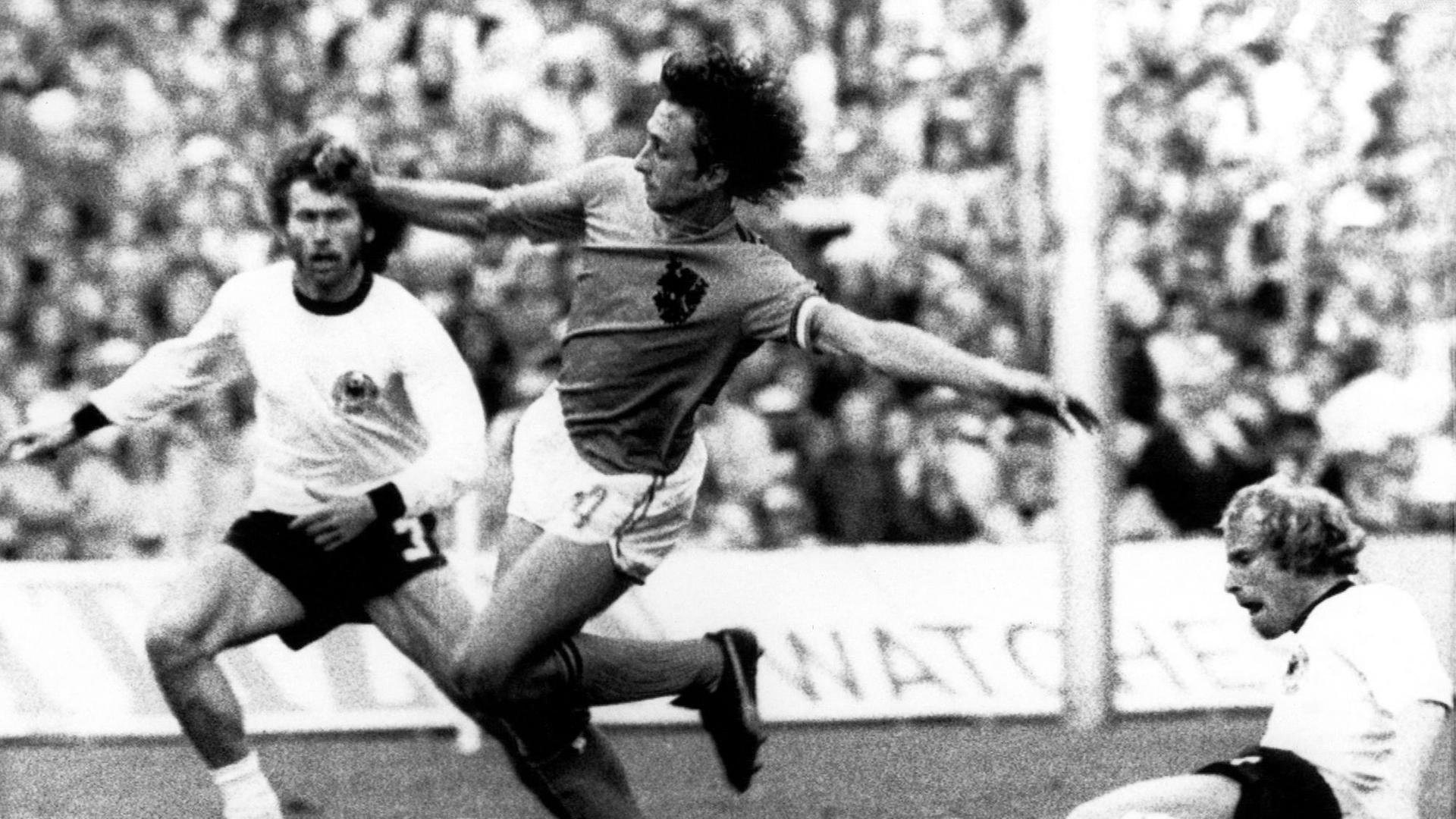 Man sieht Johan Cruyff zwischen Paul Breitner und Berti Vogts im Finale von der WM 1974.
