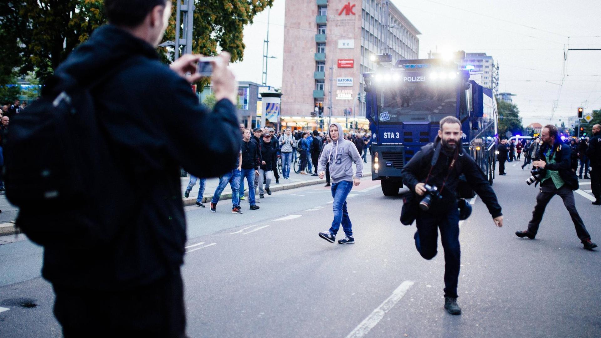 Ein Journalist flüchtet vor den Angriffen von rechten Demonstrationsteilnehmern beim Schweigemarsch von AfD und Pegida in Chemnitz.
