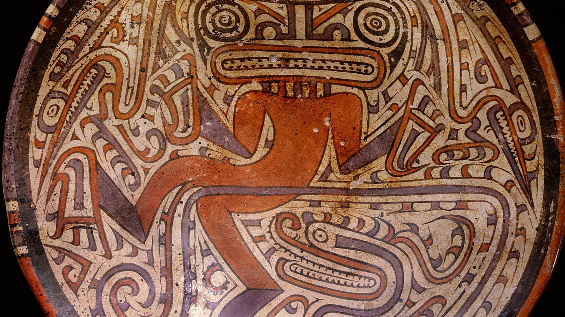Eine südamerikanische Trommel, wo eine Schlange und ein Schamane abgebildet sind.
