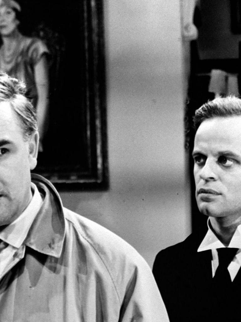 Filmstill aus "Edgar Wallace: Der Schwarze Abt": Joachim Fuchsberger telefoniert, im Hintergrund Klaus Kinski.