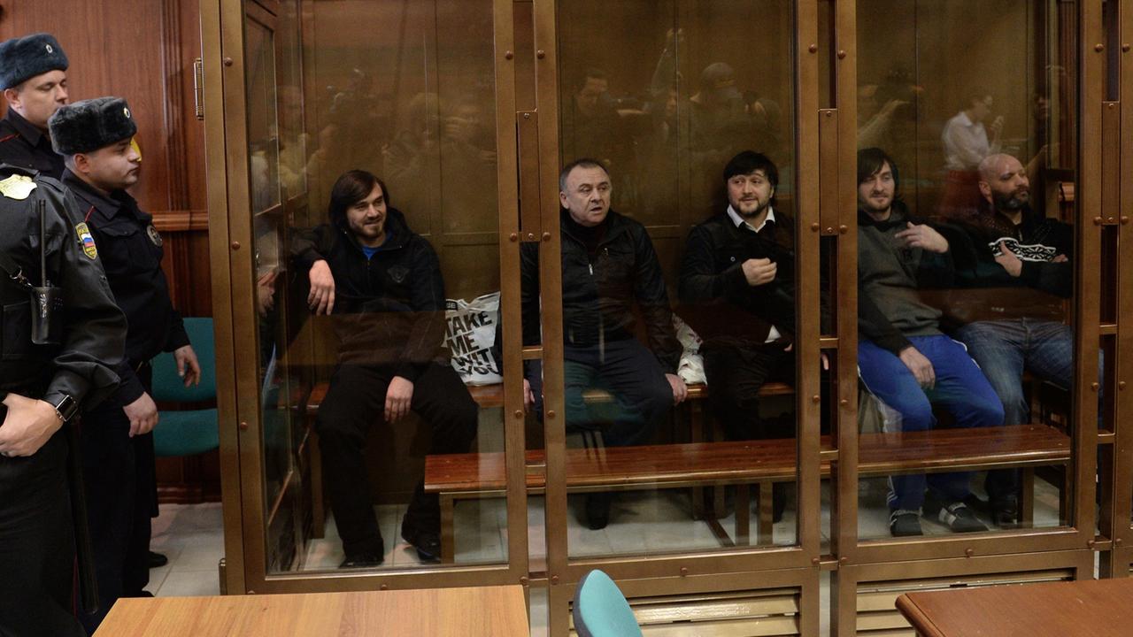 Die fünf Angeklagten im Mordfall Politkowskaja sitzen während der Verhandlungen im Glaskäfig in einem Moskauer Gericht.
