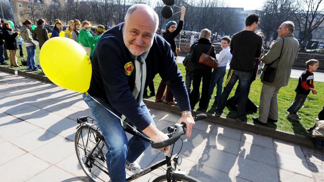 Rezzo Schlauch fährt Rad. An seinem Fahrrad ist ein gelber Luftballon befestigt.