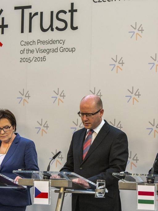 Der slowakische Premierminister Robert Fico, Polens Premierministerin Ewa Kopacz, der tschechische Premierminister Bohuslav Sobotka und der ungarische Premierminister Viktor Orban stehen in einer Reihe nebeneinander an Mikrofonen.