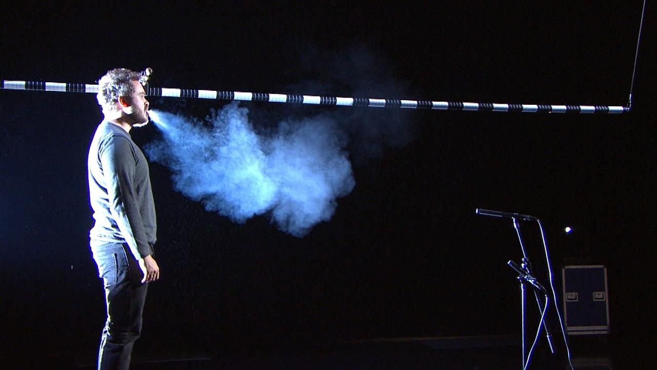 Ein Sänger stößt beim Singen eine Aerosol-Wolke aus.