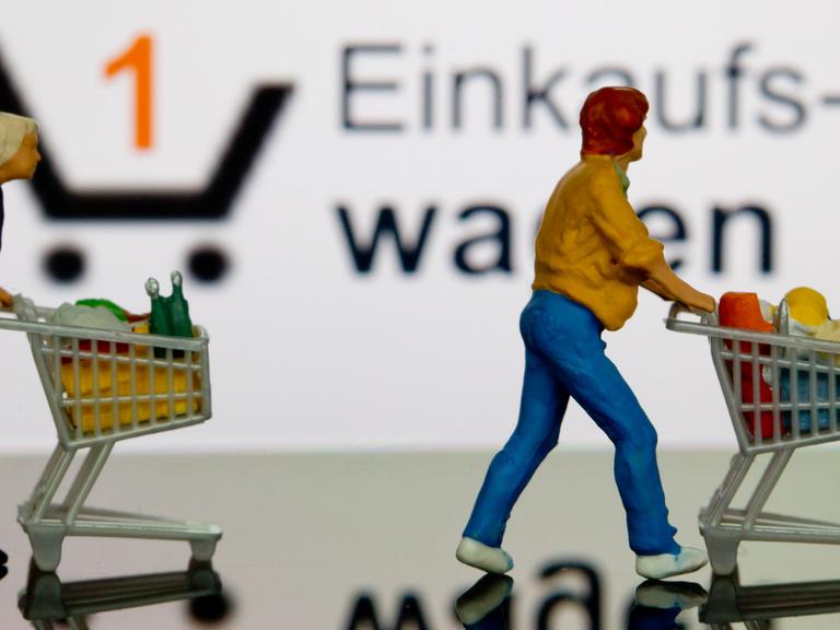 Symbolbild: Eine kleine Frauenfigur steht mit Einkaufswagen auf einer Tastatur