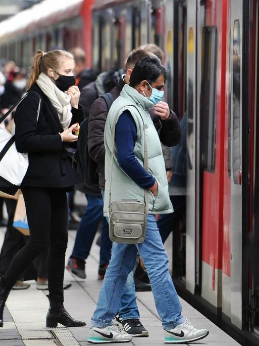 Maskenpflicht im oeffentlichen Personennahverkehr. S-Bahn Muenchen am 12.10.2020. Auf dem Bahnsteig steigen Fahrgaeste mit Mundschutz,Maske in einen Zug - alle tragen Masken.