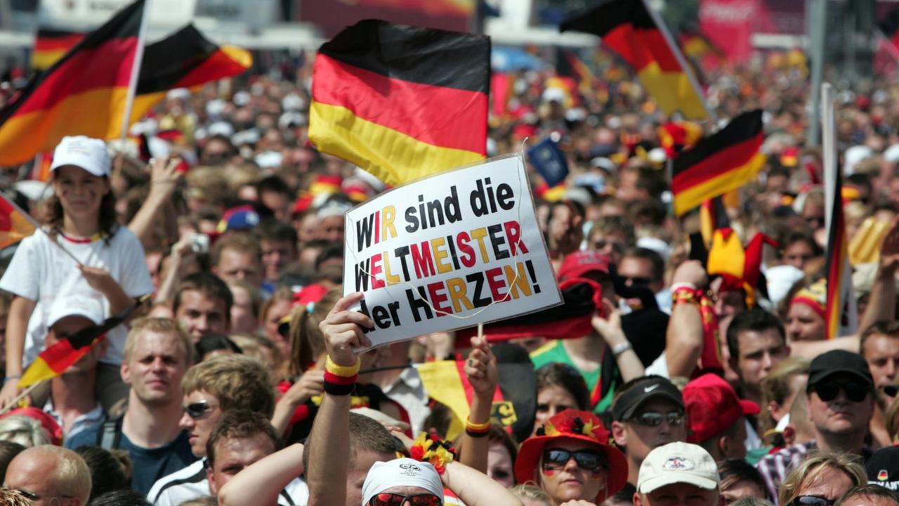 Viele Menschen feiern mit schwarz-rot-goldener Kleidung und Deutschland-Fahnen