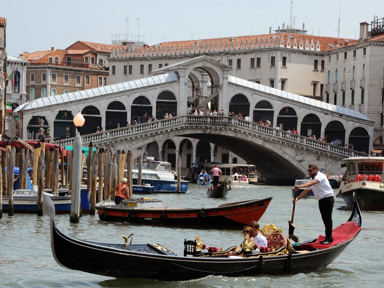 Gondeln, Boote und ein Vaporetto fahren auf dem Canale Grande vor der Rialtobrücke in Venedig