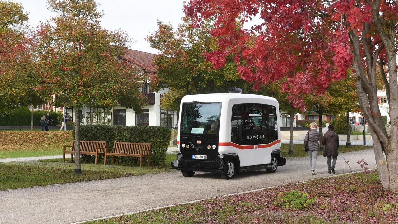 Ein autonom-fahrender Mini-Bus fährt am 25.10.2017 in Bad Birnbach (Bayern) auf einer Straße und wird von Passanten betrachtet