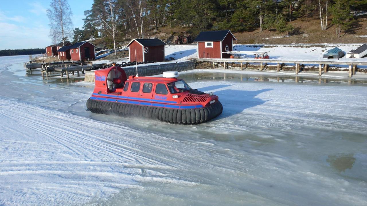 Das Luftkissenboot auf der Eisfläche vor Holzhäusern