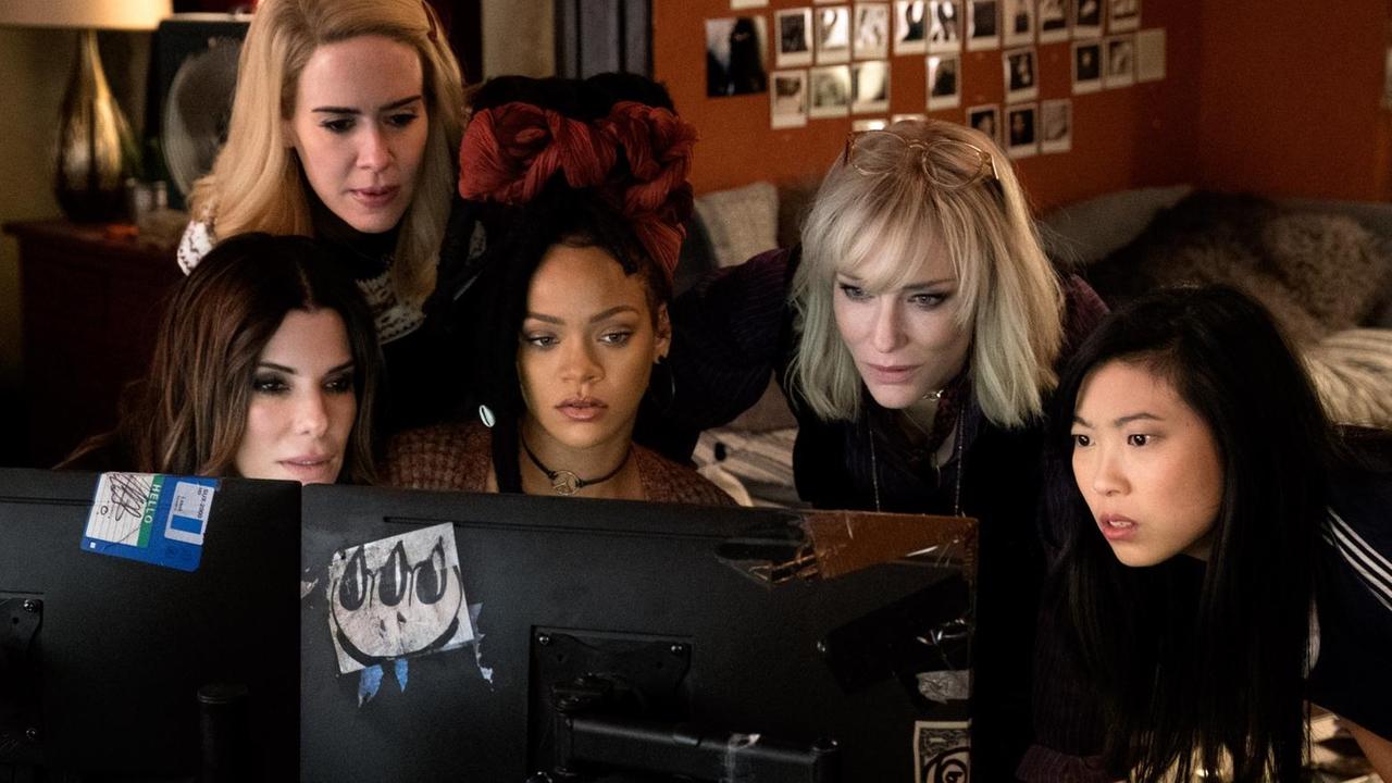Filmszene aus "Ocean's 8": Sandra Bullock, Sarah Paulson, Rihanna, Cate Blanchett und Awkwafina gruppieren sich um einen Computer.