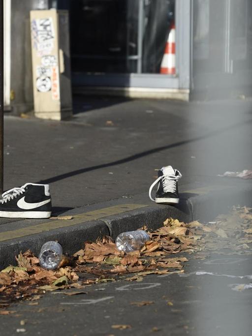 Ein Paar Schuhe liegt auf einer Straße vor der Pariser Konzerthalle Bataclan.