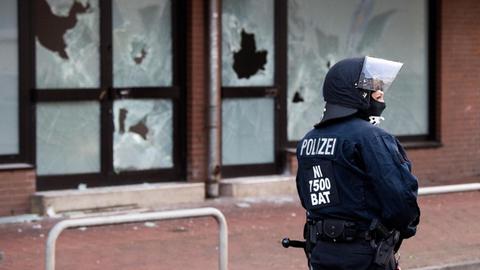 Eine Polizistin steht in voller Ausrüstung und mit Helm vor der DIK-Moschee in Hildesheim.