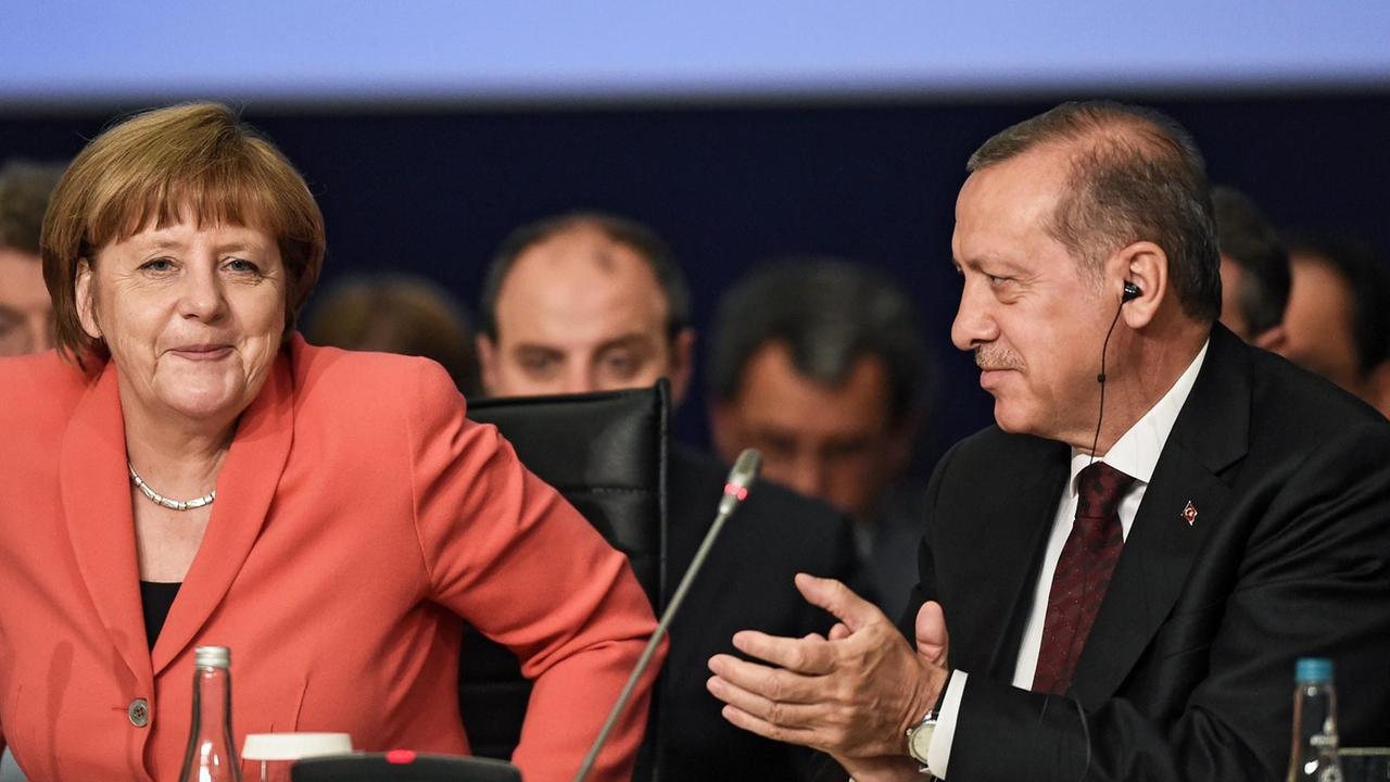 Angela Merkel mit Recep Tayyip Erdogan am 23. Mai 2016 in Istanbul. Merkel lächelt, Erdogan klatscht in die Hände.