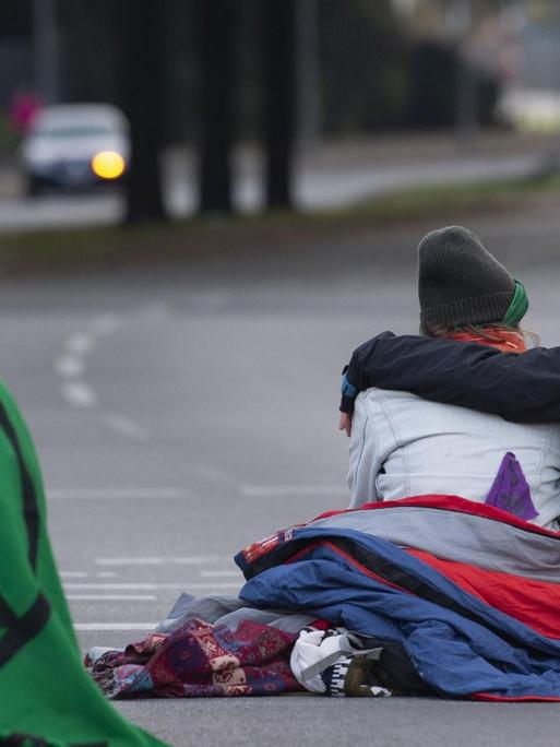 Aktivisten der Klimabewegung "Extinction Rebellion" blockieren sitzend eine Straße in Berlin.