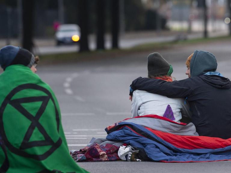 Aktivisten der Klimabewegung "Extinction Rebellion" blockieren sitzend eine Straße in Berlin.