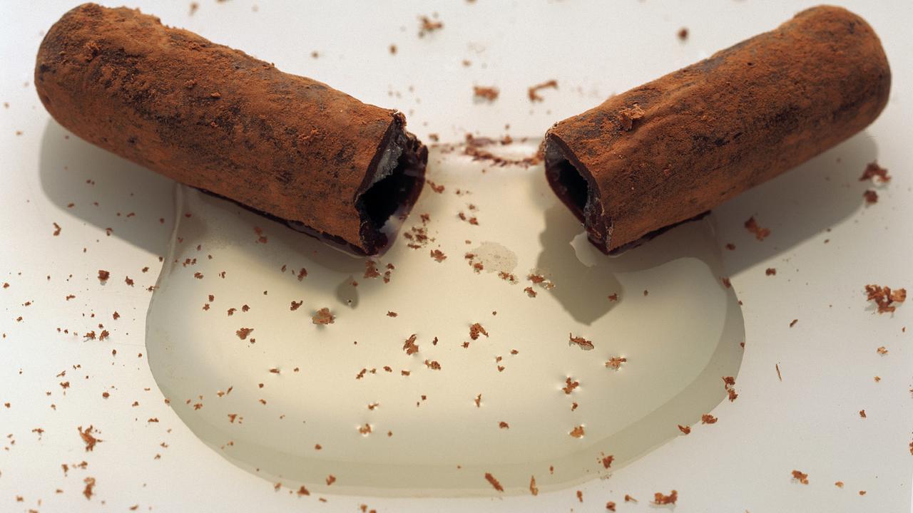Mit Kakaopuder bestäubte Schokoladenstangen mit Kirchwasserfüllung.
