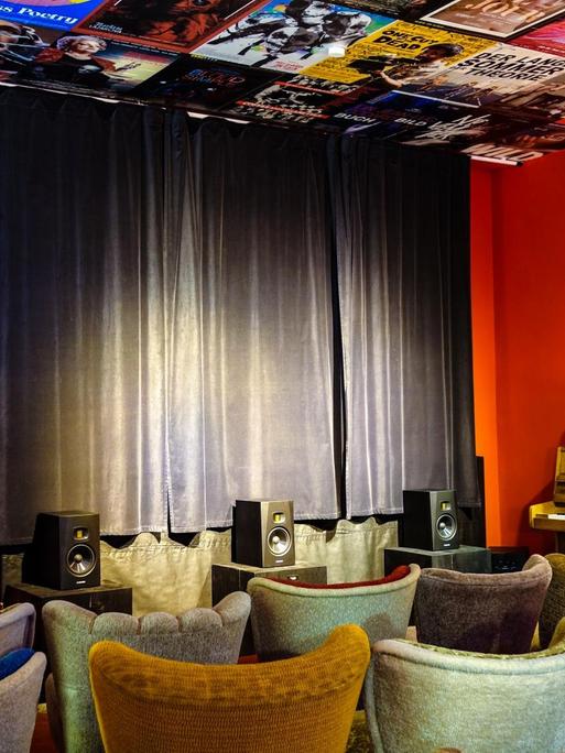 Der kleine Kinoraum ist bestückt mit bunten Sesseln und im typischen Kinorot gestrichen.