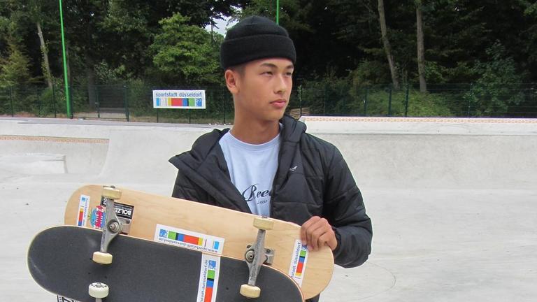 Der Skater Lenni Janssen hält 3 Skateboards in seinen Armen.
