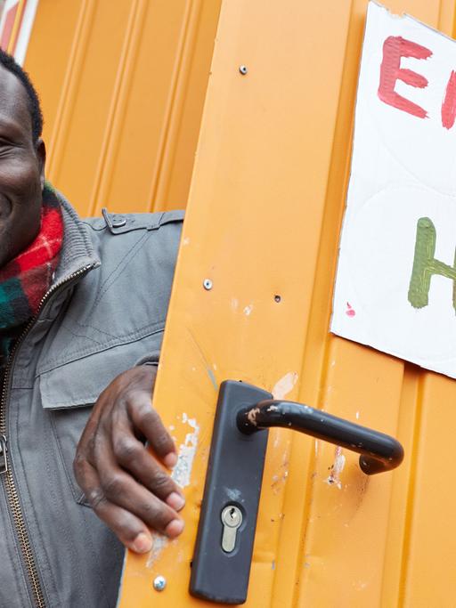 Der Ghanaer Andreas Listowell als Vertreter der "Lampedusa-Flüchtlinge" an der Tür eines Bauwagens mit der Aufschrift "Embassy of Hope". Der durch Spenden über Kiezhelden.com finanzierte Bauwagen soll den Flüchtlingen als Anlaufstelle und Treffpunkt dienen. Foto: Georg Wendt/dpa