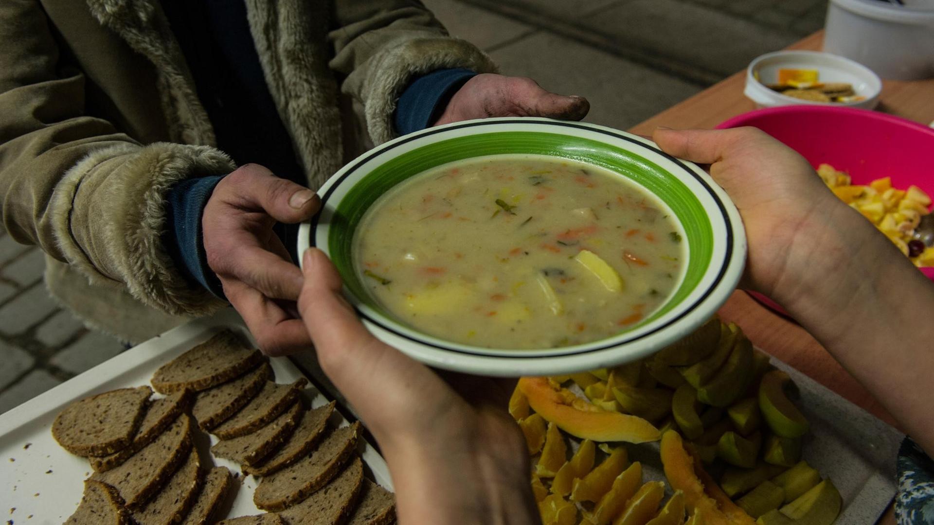 Ein Obdachloser bekommt am 19.02.2014 in Berlin eine Suppe in einer Wärmelufthalle. Die Berliner Stadtmission hat das provisorisch errichtete Gebäude als Nachtquartier für Obdachlose unweit des Innsbrucker Platzes vorgesehen.