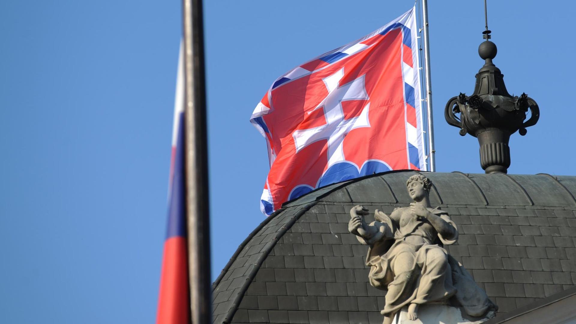 Die slowakische Flagge weht auf dem Präsidialpalast in Bratislawa (Slowakei). Die slowakische Flagge weht auf dem Präsidialpalast in Bratislawa (Slowakei).