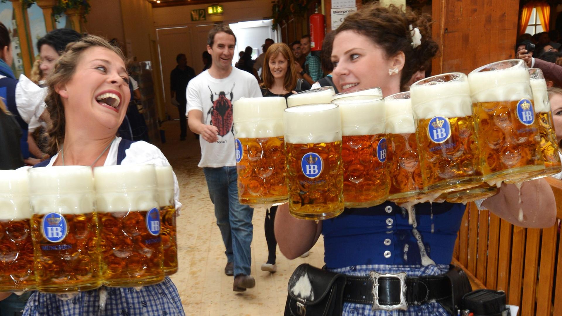 Bedienungen bei der Eröffnung des 180. Oktoberfests am 21.09.2013 in München (Bayern) mit Bierkrügen.