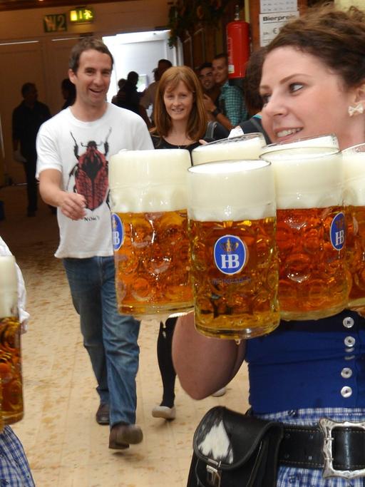 Bedienungen bei der Eröffnung des 180. Oktoberfests am 21.09.2013 in München (Bayern) mit Bierkrügen.