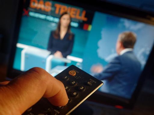 Das erste von drei TV-Triellen zur Bundestagswahl 2021: Fernsehbildschirm mit CDU-Kanzlerkandidat Armin Laschet und Interviewerin Pinar Atalay, im Vordergrund eine TV-Fernbedienung.
