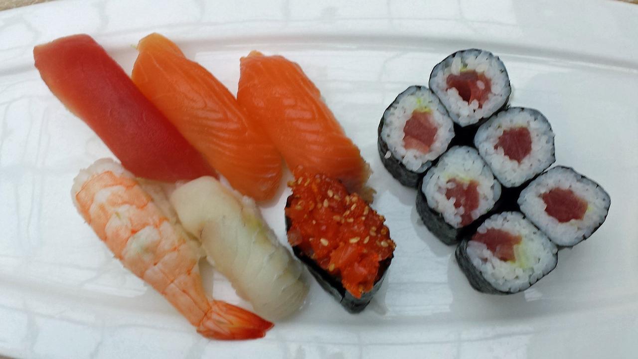 Unterschiedliche Sorten Sushi liegen auf einem weißen Teller.