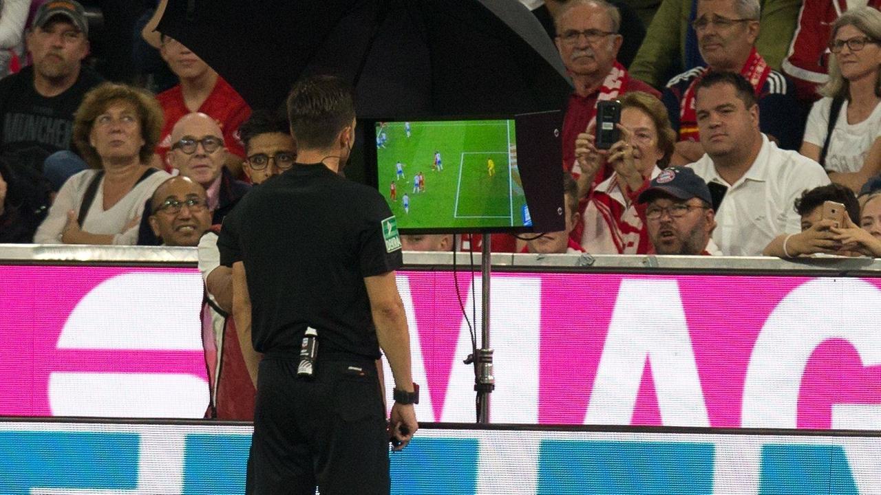 Schiedsrichter, Referee, Harm Osmers schaut auf einen Monitor und kontrolliert mit dem Videobeweis pb es sich um ein Foul handelte.
